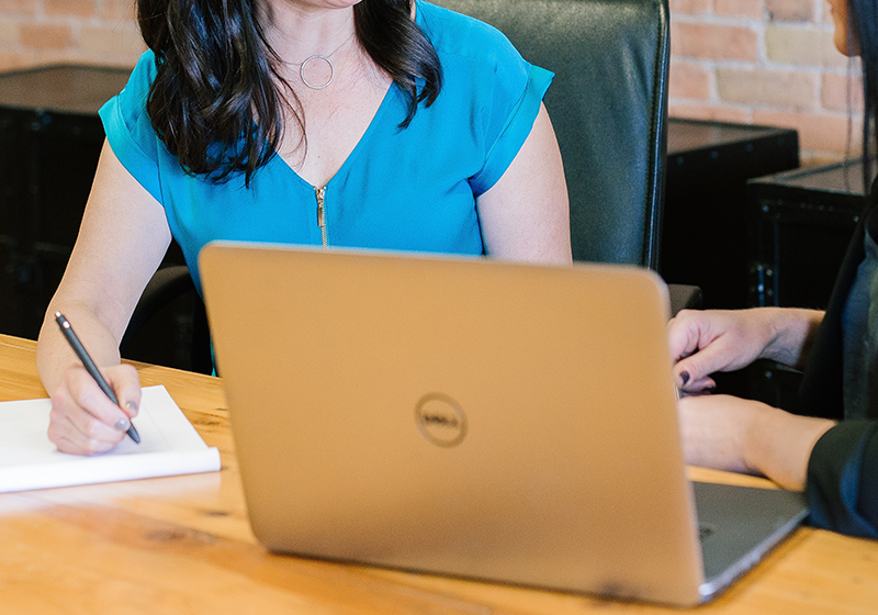 women in business coaching and talking at a boardroom table